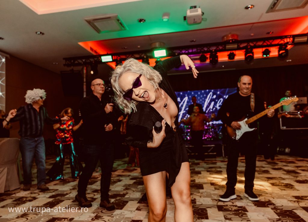 Sasha, solista Trupei Atelier, cântă printre invitați pe ringul de dans la o gală corporate la Hotel Clermont din Covasna